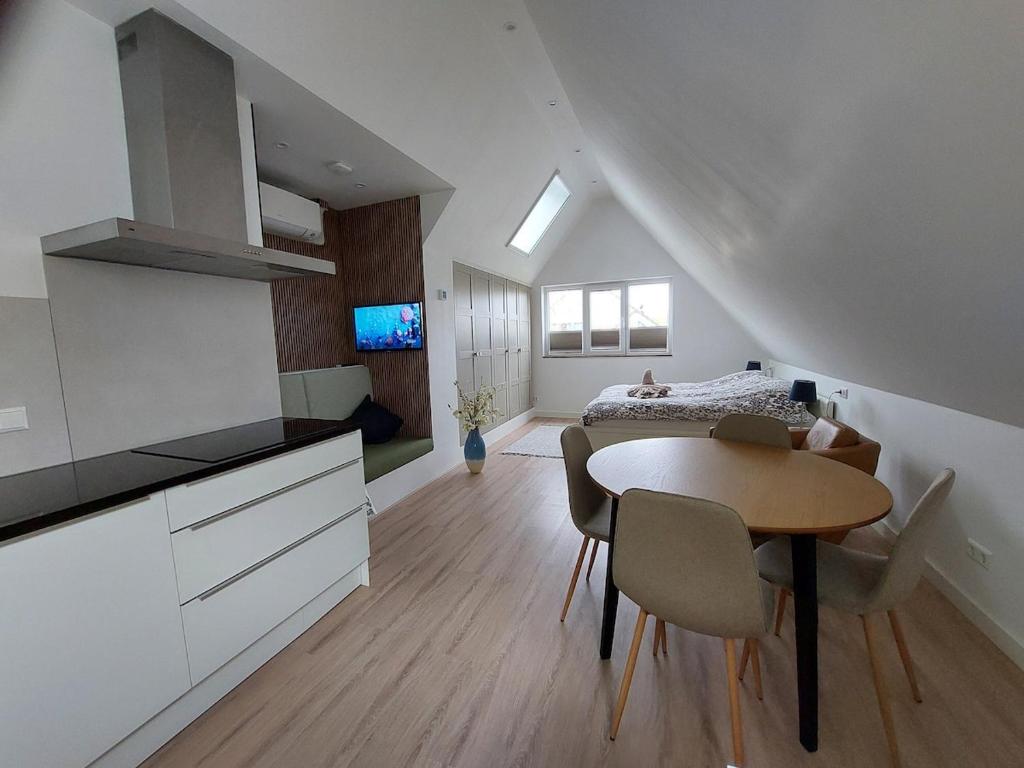 a kitchen and dining room with a table and a bedroom at Comfort Apartment Hoofddorp near Amsterdam Schiphol in Hoofddorp