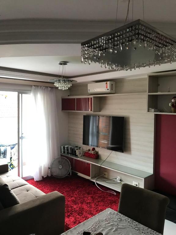 Una sala de estar con un sofá y un televisor de pantalla plana. en Eco Residência, en Ananindeua
