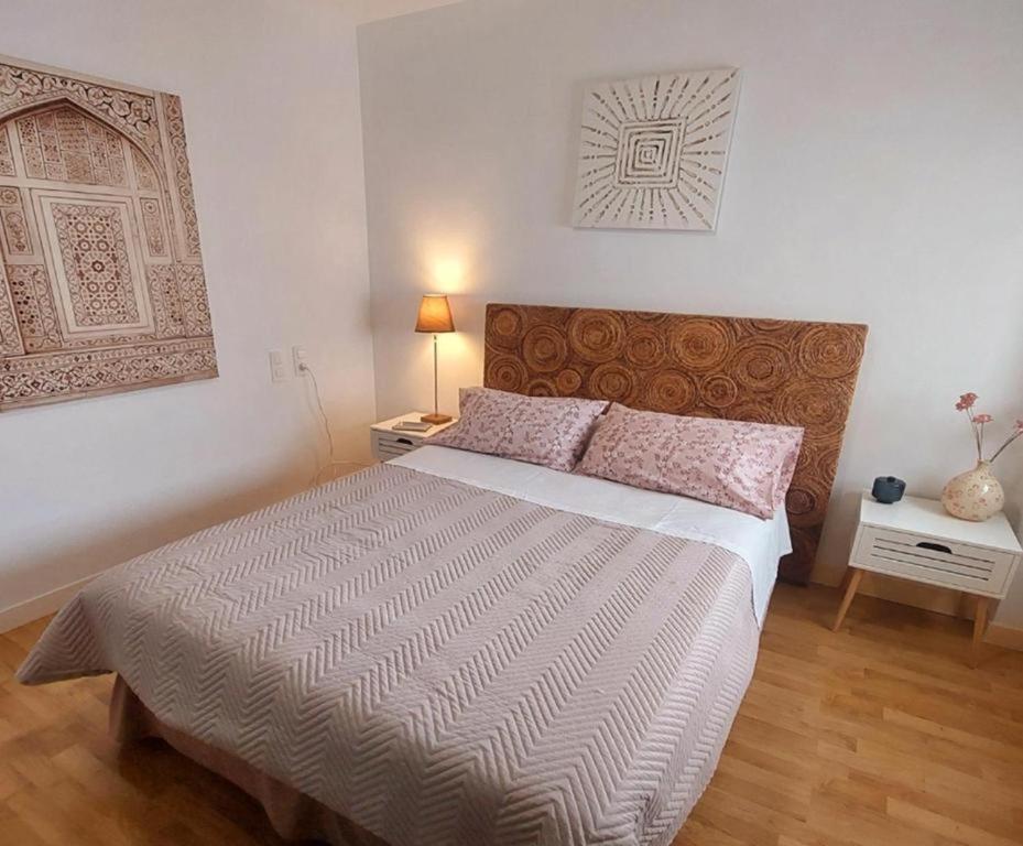 a bedroom with a large bed and a lamp at Amplio apartamento con terraza con vistas "Victoria Stay" in Alcalá la Real