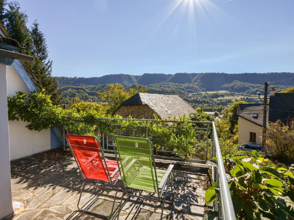 three chairs sitting on a balcony with a view at Vic-sur-Cère Family Nest in Vic-sur-Cère