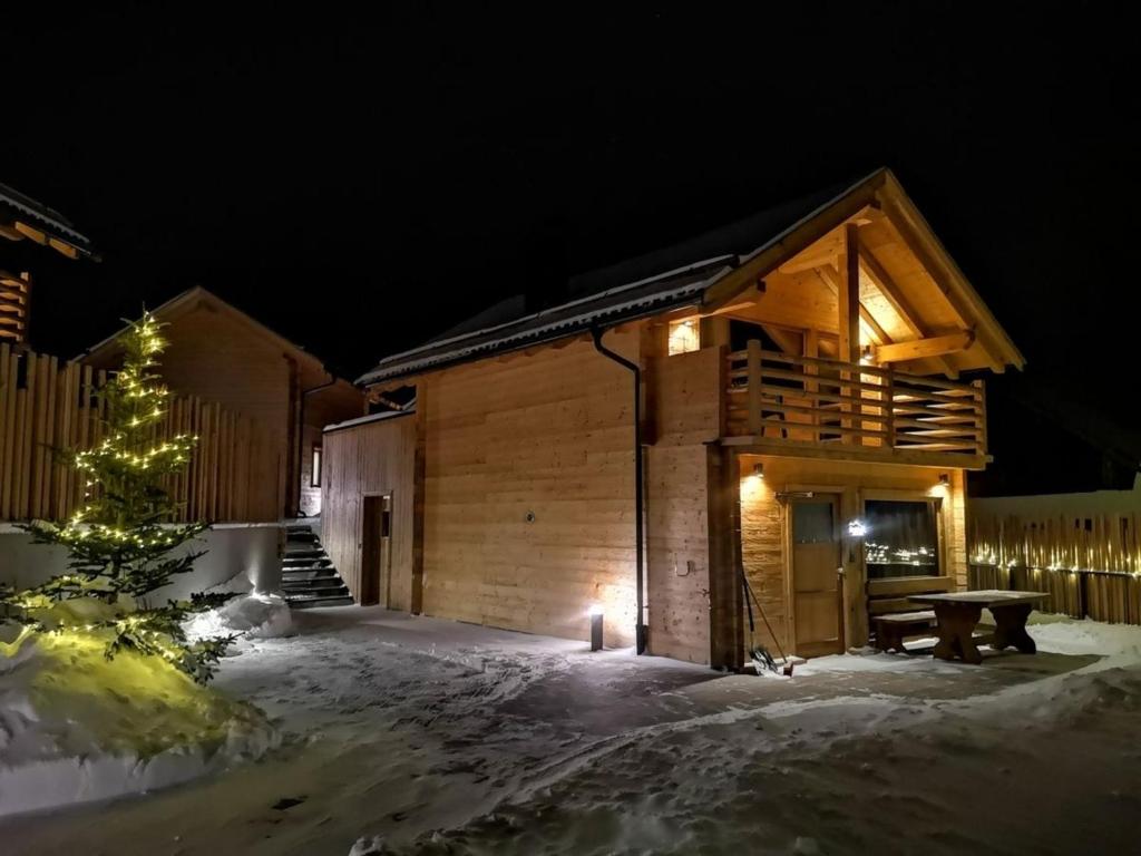 eine Blockhütte im Schnee bei Nacht in der Unterkunft Chalets Lagaun in Villetta