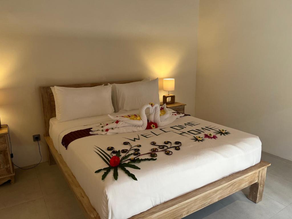 a bedroom with a large white bed with flowers on it at The Banjar Homestay in Sidemen
