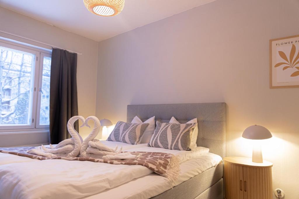 a bedroom with a large bed with two swans on it at Santa's City Suite by Book Lapland in Rovaniemi
