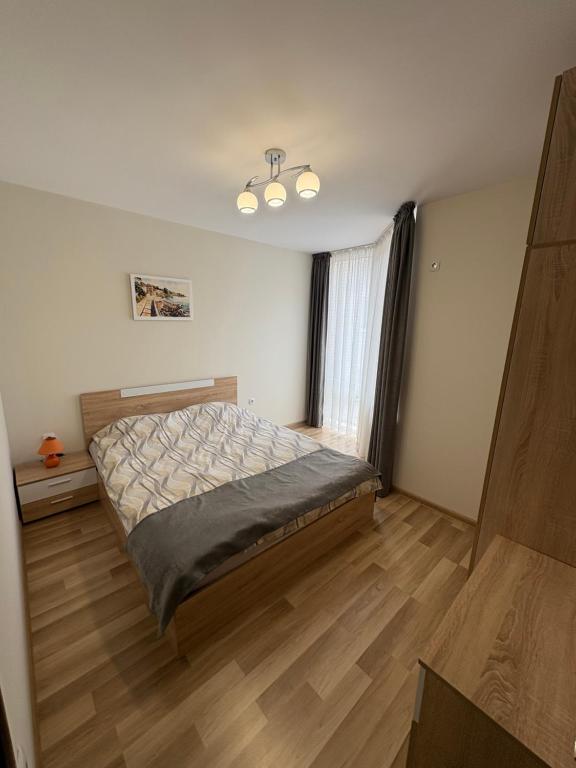 a bedroom with a bed and a wooden floor at Nikea apart 2 in Velingrad