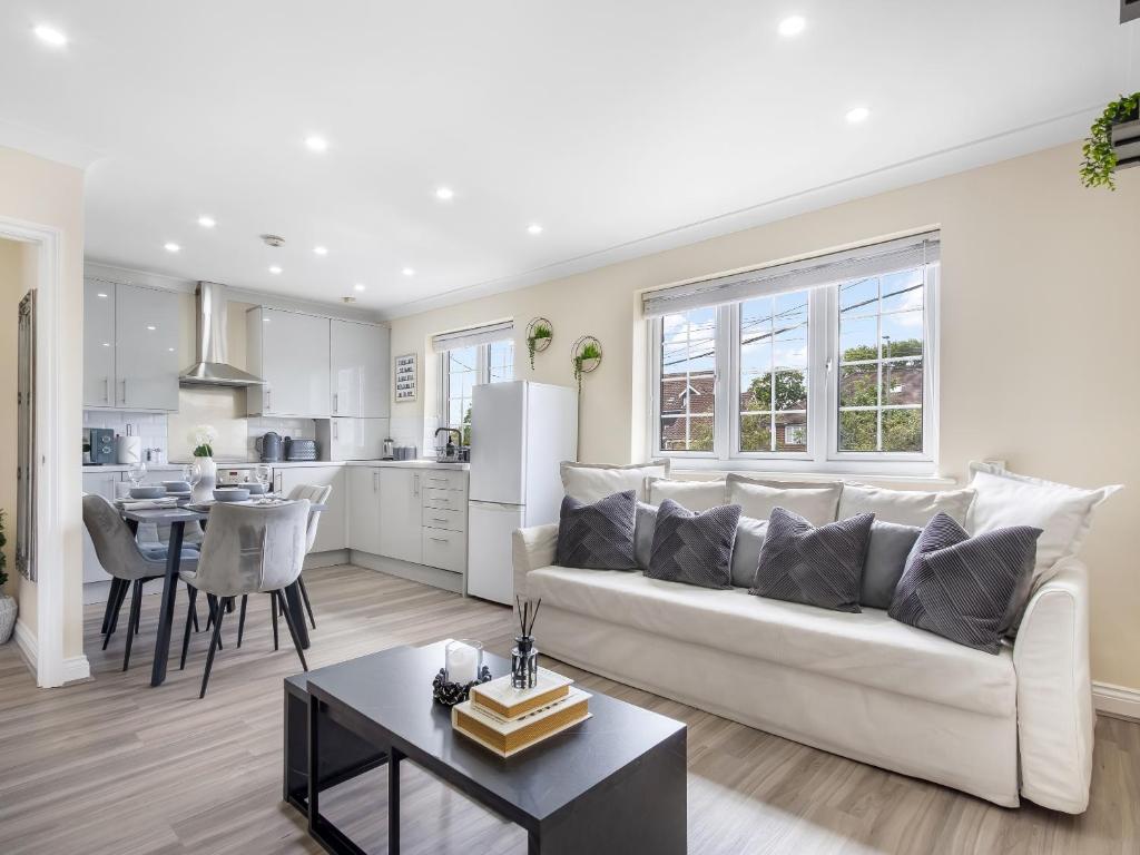a white living room with a couch and a table at Lavish 1 Bedroom Apartment in London