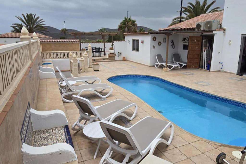 un patio avec des chaises et une piscine dans l'établissement 3 Bed Villa - Sleeps 6 - Private Pool - Hot Tub- Parking - Wifi, à San Miguel de Abona
