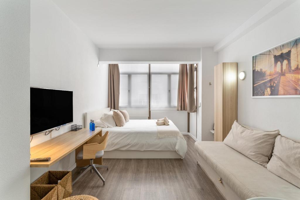 ein Hotelzimmer mit Bett und Schreibtisch in der Unterkunft Siempreviva Beach Las Canteras in Las Palmas de Gran Canaria