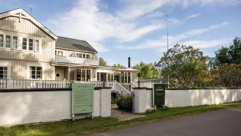 a white house with a sign in front of it at Naya Retreat & Hotell in Mörbylånga