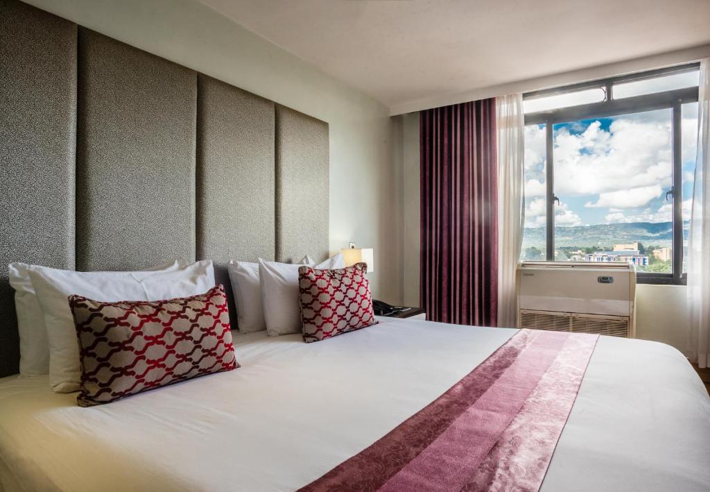 a bedroom with a large bed with pillows and a window at Gelian Hotel in Machakos