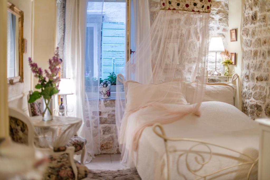 Cama blanca en habitación con ventana en Villa Segalla, en Rovinj