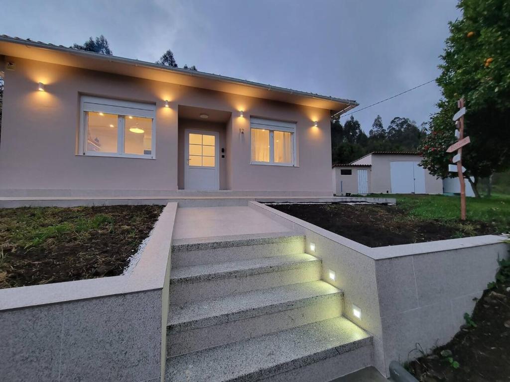 a house with lights on the stairs in front of it at Casa de Nuna - Netflix in Cabana de Bergantiños