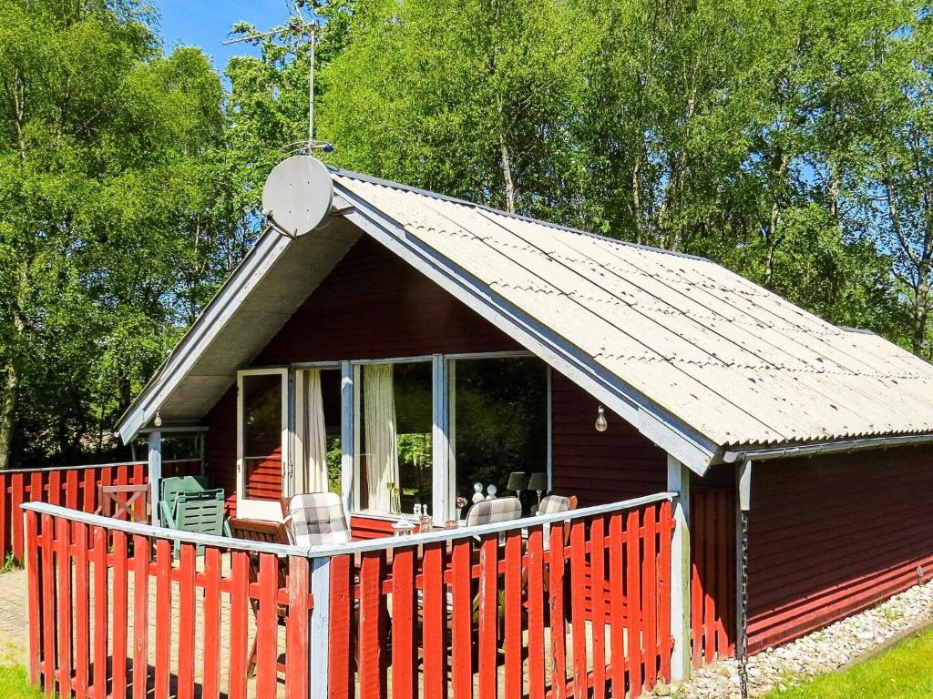 a small red house with a red fence at 4 person holiday home in Hals-By Traum in Hals