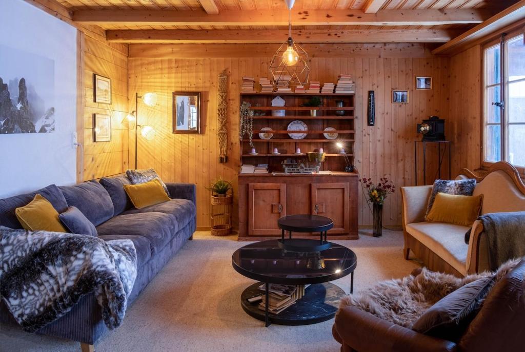 a living room with a couch and a table at Cozy chalet in Kandersteg in Kandersteg