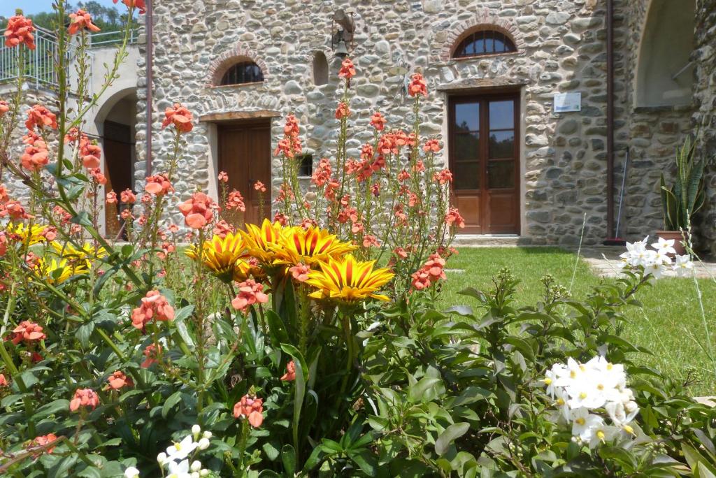 een tuin met bloemen voor een stenen gebouw bij La Peschiera Sul Vara B&B in Sesta Godano