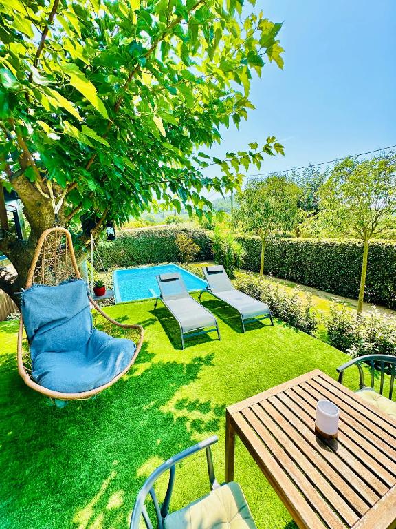 a backyard with chairs and a hammock and a table at The Green Wagon Costa Brava, Piscina Privada, AC, WIFI, Parking, Terraza in Tordera