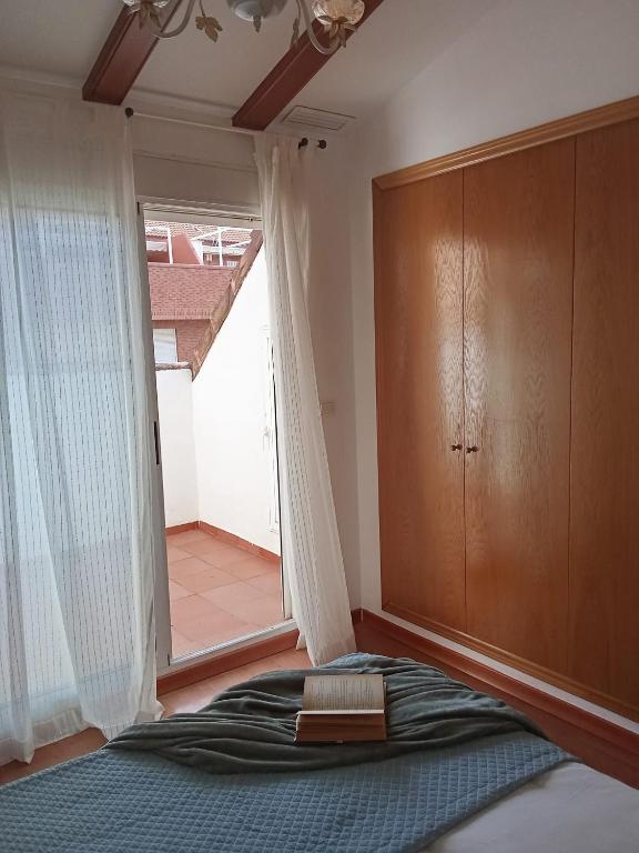 a bedroom with a bed and a large window at Valencia Casa Rosa in Sedaví