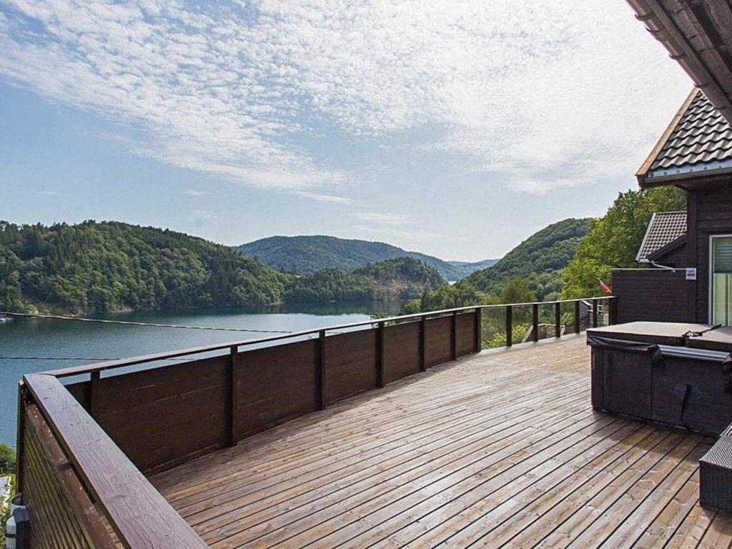 a wooden deck with a view of a lake at 4 star holiday home in Lyngdal in Lyngdal