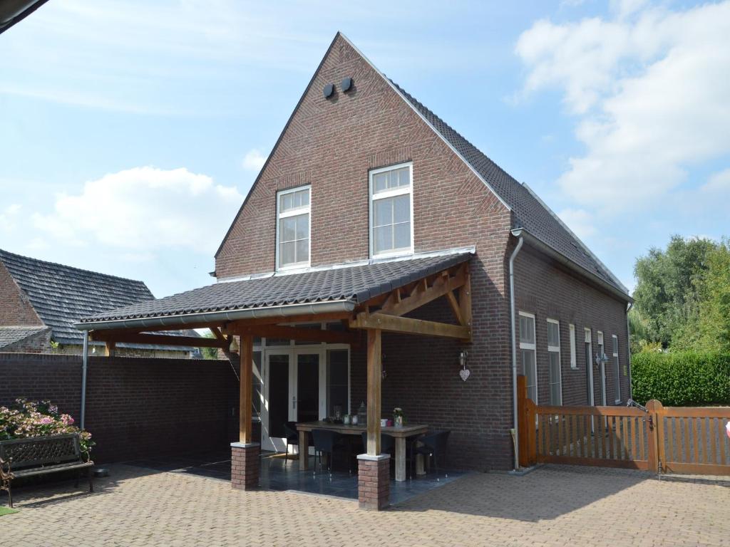 a brick house with a gambrel roof with a patio at Apartment in Posterholt near Meinweg Park in Posterholt