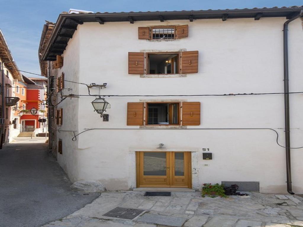 a white building with wooden windows and a door at Holiday Home in Vodnjan near the Sea in Vodnjan