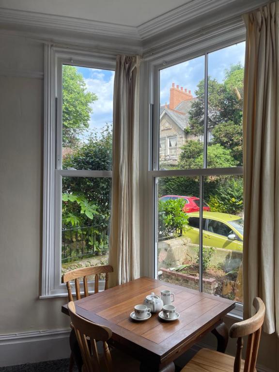 a table in a room with a large window at Penzance Central 1 & 2 Bedroom flats in Penzance