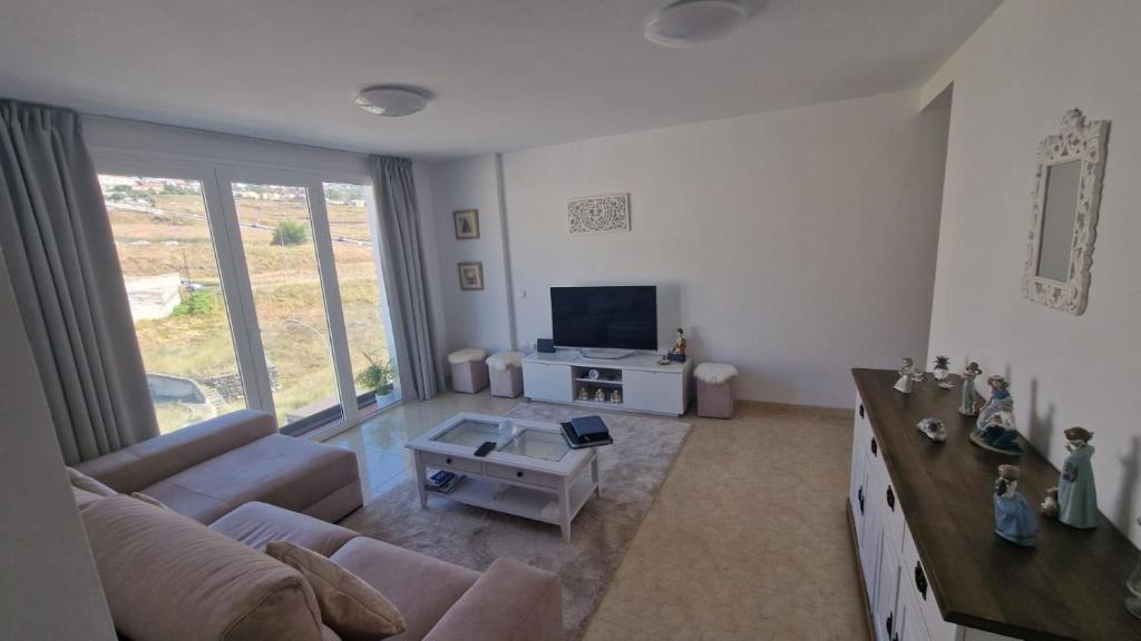 a living room with a couch and a tv at San Isidro in San Isidro