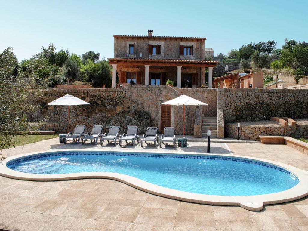 a pool with chairs and a house in the background at Villa in Mallorca with Private Pool in Marratxi