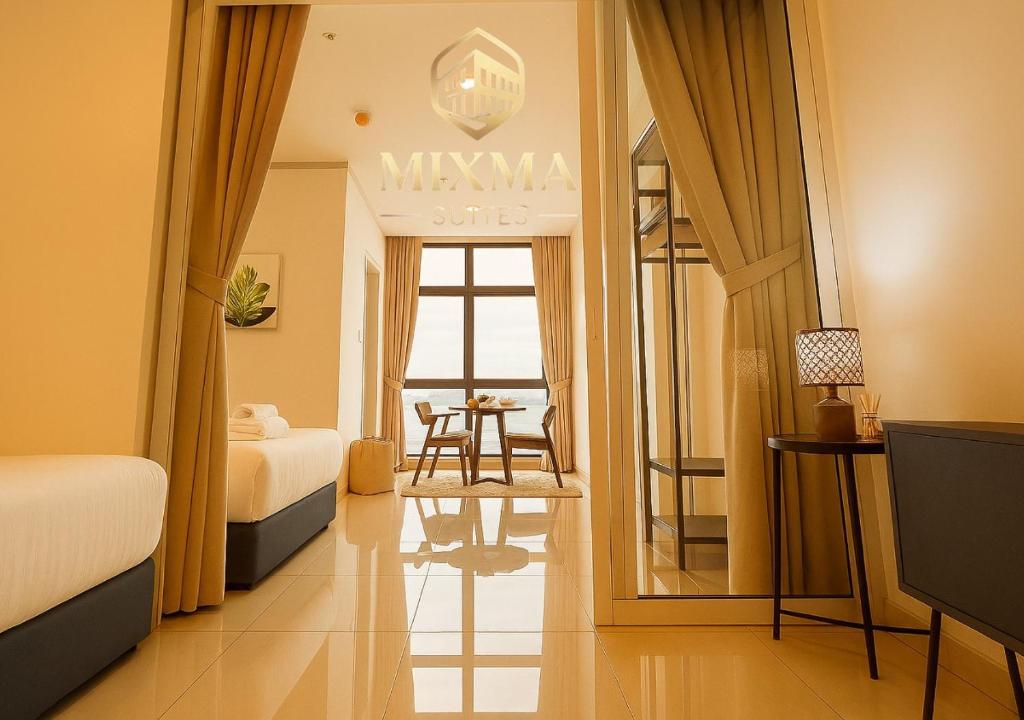 a hotel room with two beds and a table at Panoramic Seaview KK City The Shore at Mixma Suites in Kota Kinabalu