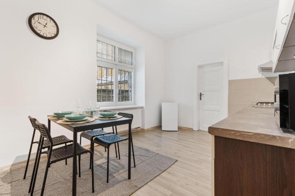 Una cocina con una mesa con sillas y un reloj en la pared. en City Center Suite - Modern & Stylish, en Bratislava