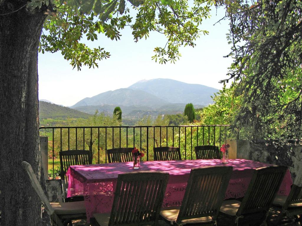a pink table with chairs and a view of mountains at Holiday Home near Mont Ventoux Pool in Vaison-la-Romaine