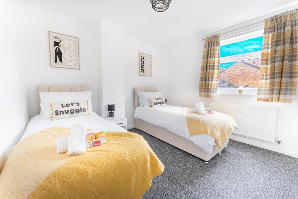a bedroom with two beds and a window at City Centre House with Secure Driveway Parking, Neflix, Garden, Long Stay Savings in Liverpool