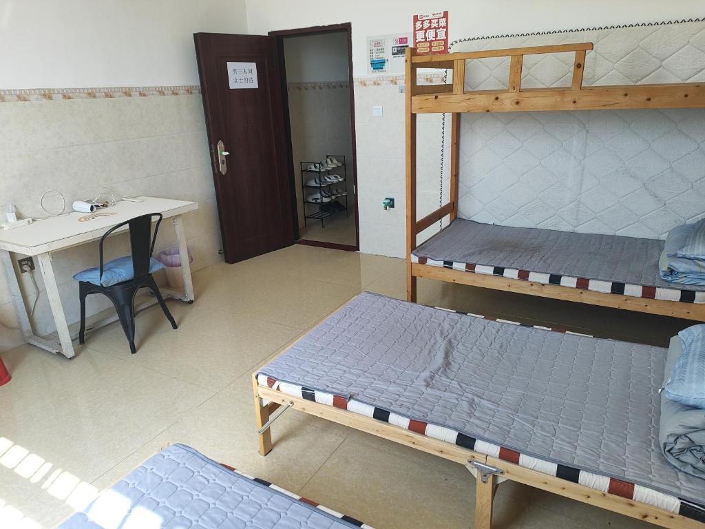 a room with two bunk beds and a desk at Dongfang City Erlihai Youth Hostel 