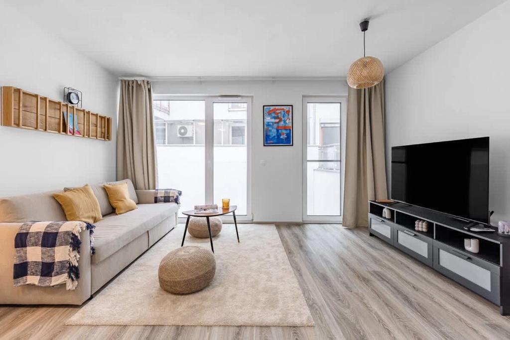 a living room with a couch and a tv at Modern and Cozy flat with Balcony in Bratislava
