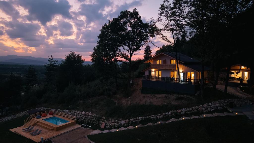 una casa con piscina frente a una puesta de sol en Cabana Sub Stejari 2, en Râșnov