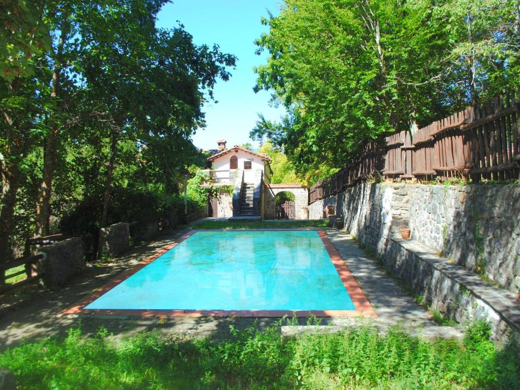 an old swimming pool in front of a house at Spacious Villa Retreat in San Marcello Pistoiese
