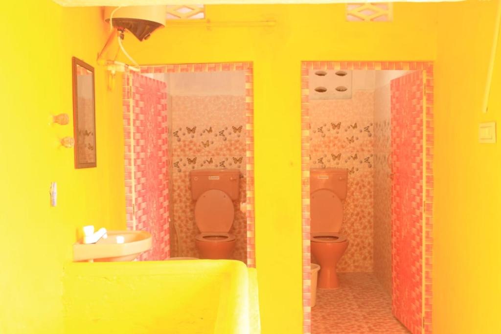 a lego bathroom with two toilets and a sink at Villa Lune Home Stay in Puducherry