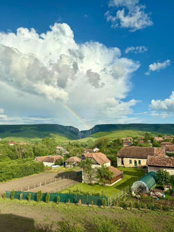 an aerial view of a village with a rainbow in the sky at Cazare Conacul Tusinean in Petreştii de Jos