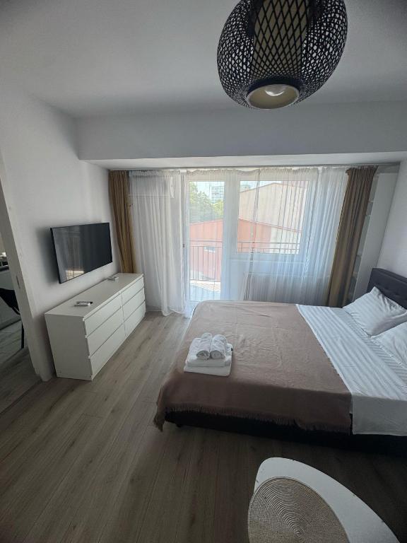Un dormitorio con una cama grande y un televisor. en Angelica Home, en Bucarest