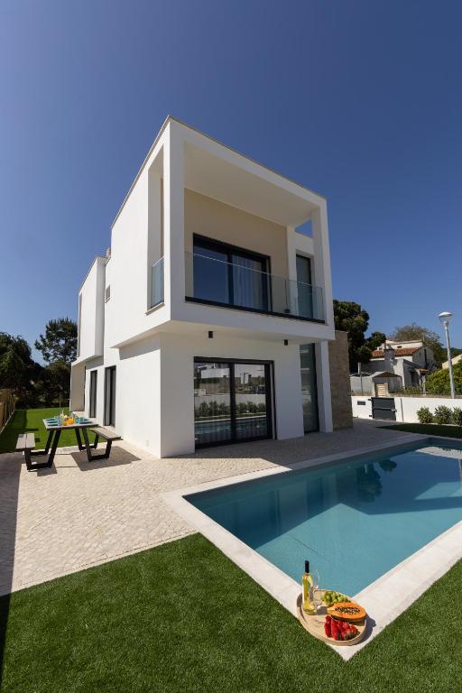 a house with a swimming pool in front of it at Lua Tranquilizante in Foz do Arelho
