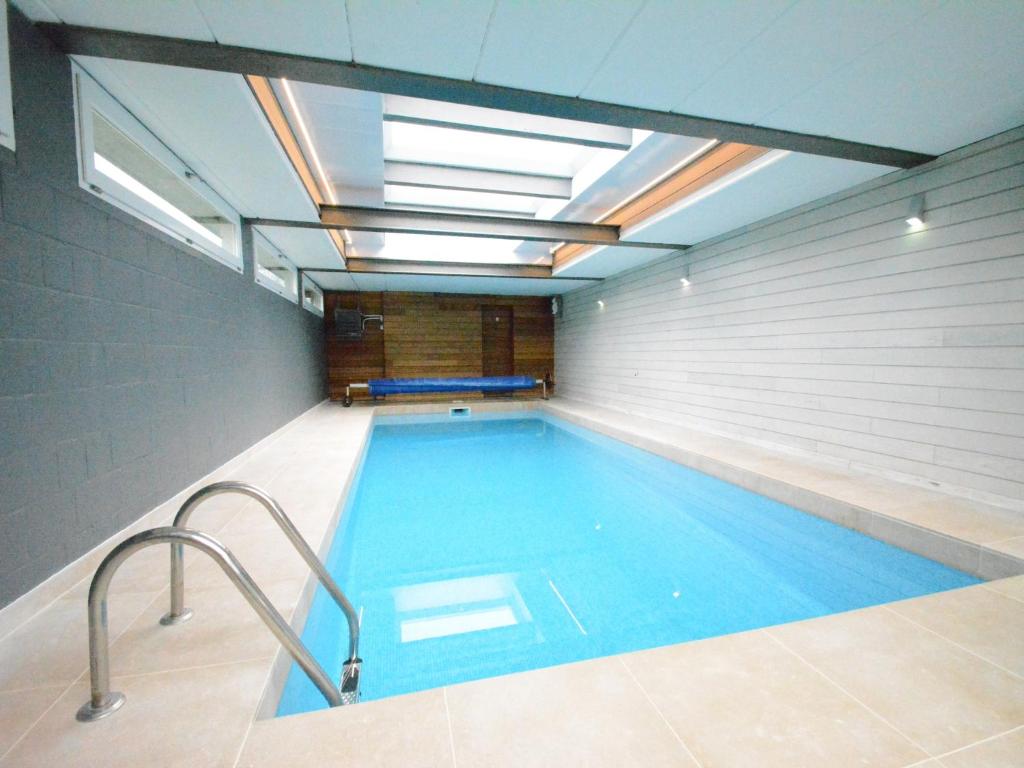 a swimming pool in a building with a ceiling at Luxury Pool Villa in Goesnes in Goesnes