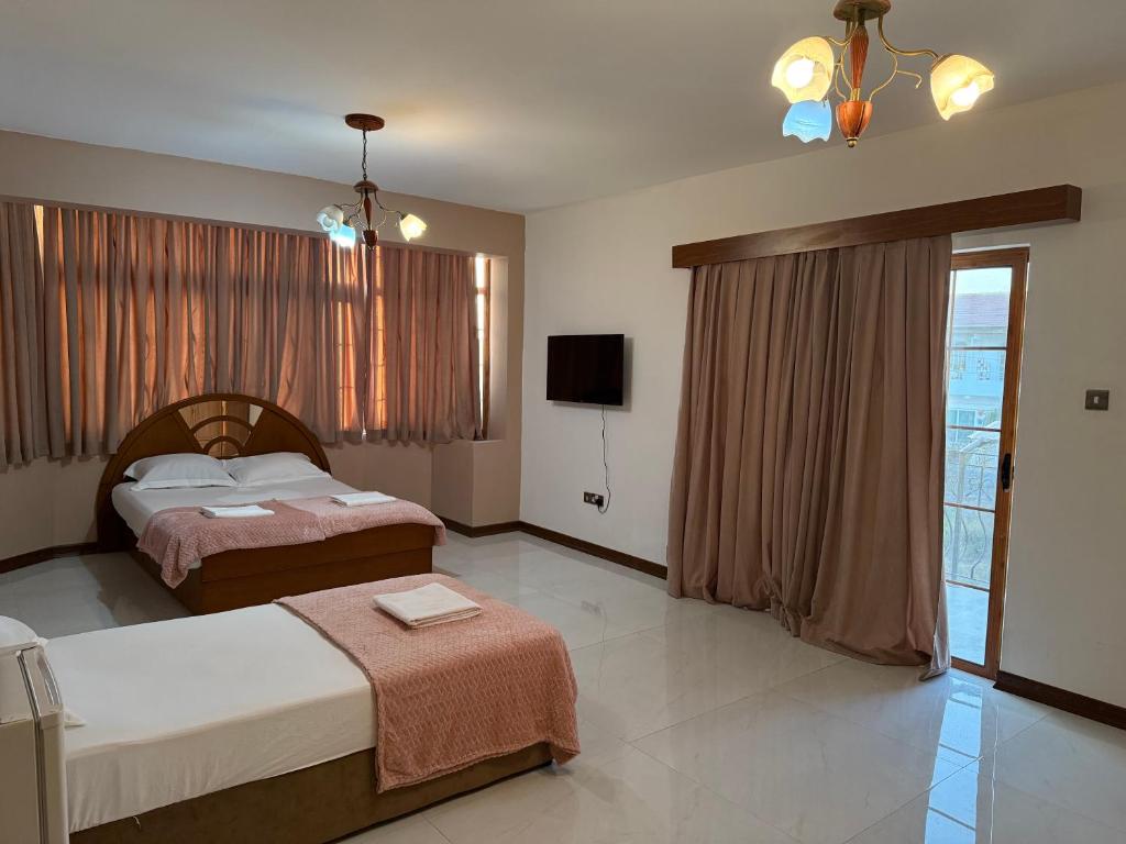 a hotel room with two beds and a television at Happiness City in Iskele