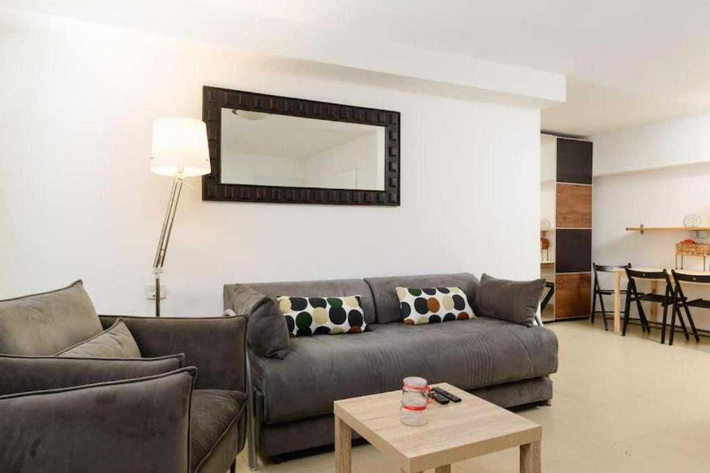 una sala de estar con un sofá y una mesa en Netanyas One Bedroom Beachside Escape, en Netanya