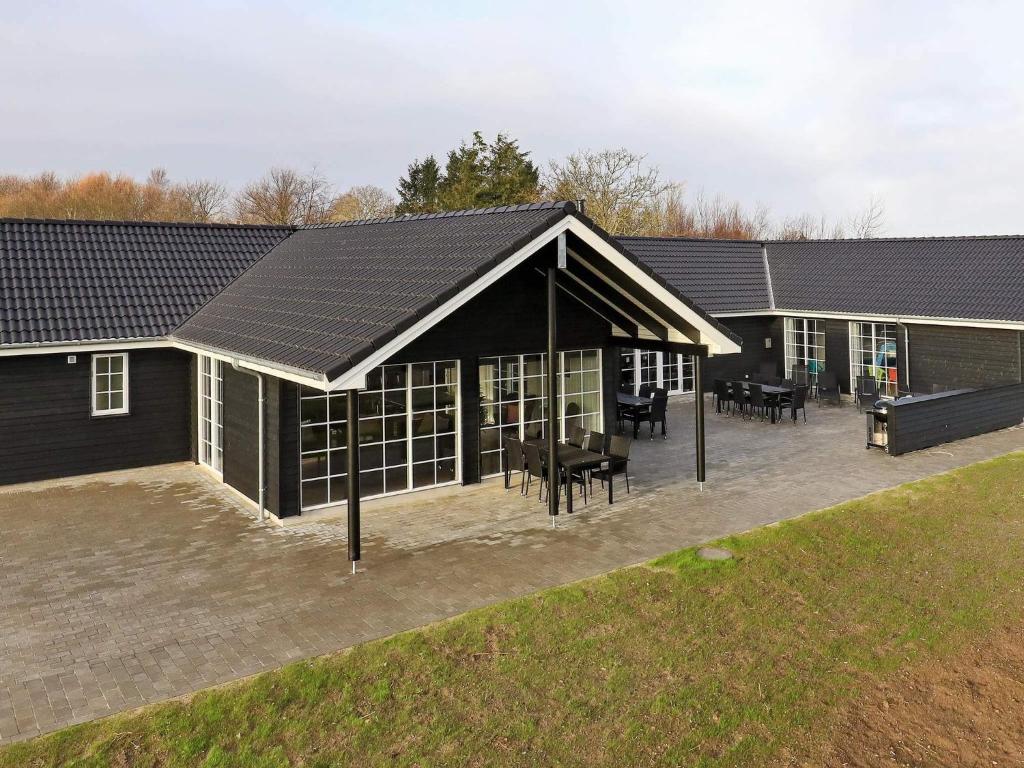 a large black building with tables and chairs at 5 star holiday home in Frørup in Frørup