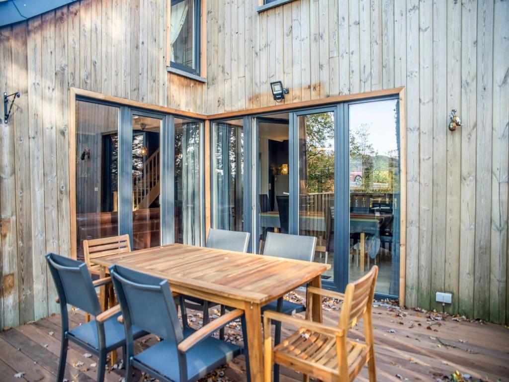 a patio with a wooden table and chairs at Peaceful Durbuy Home & Garden in Durbuy