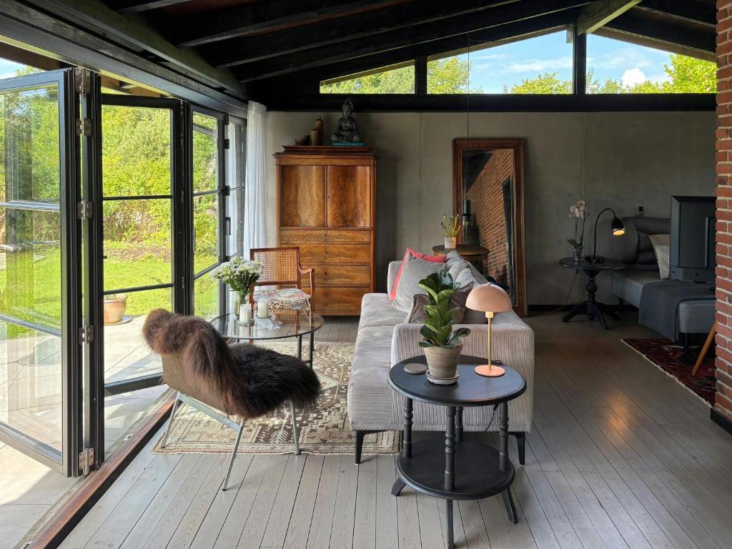 a living room with a couch and a table at Nordic Holiday Home With Fjord Views On Enø in Karrebæksminde