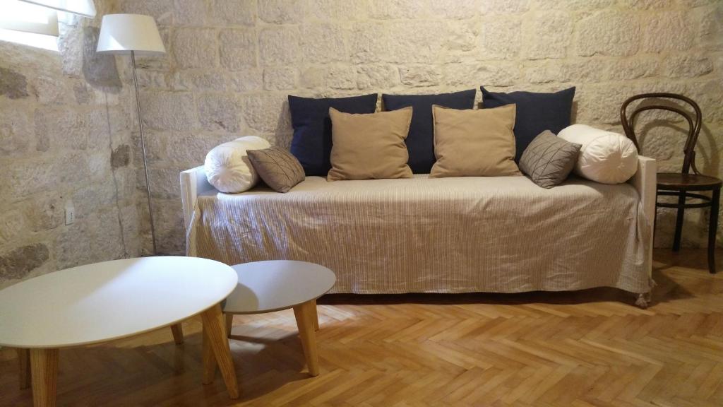 a couch with pillows on it in a room at Rooms Livia in Trogir