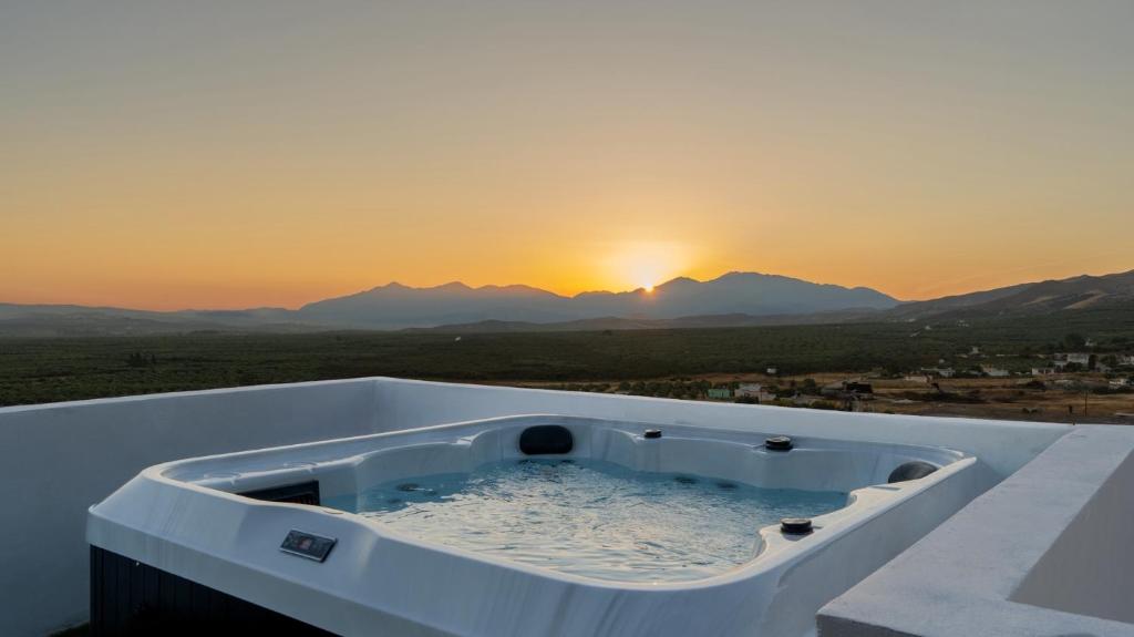 een hot tub met zonsondergang op de achtergrond bij Εunia Guest house in Rotásion
