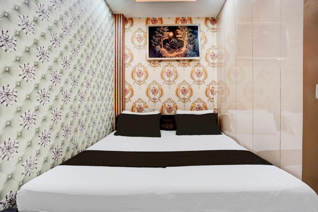 a bedroom with a white bed and a wall at Super Hotel O Signature Plaza in New Delhi