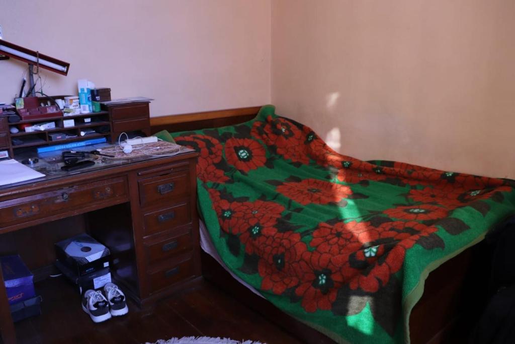 ein Schlafzimmer mit einem Bett und einem Schreibtisch mit einer Tagesdecke in der Unterkunft Magdalena Haus in Alexandria