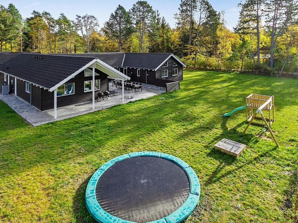 un ampio cortile con una casa e un parco giochi di Luxury Retreat in Asserbo - By Traum Ferienwohnungen a Frederiksværk