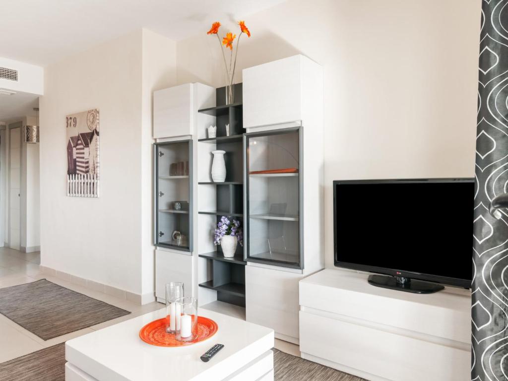 een woonkamer met een flatscreen-tv aan een witte muur bij Belvilla by OYO Valle del Este in El Esparragal